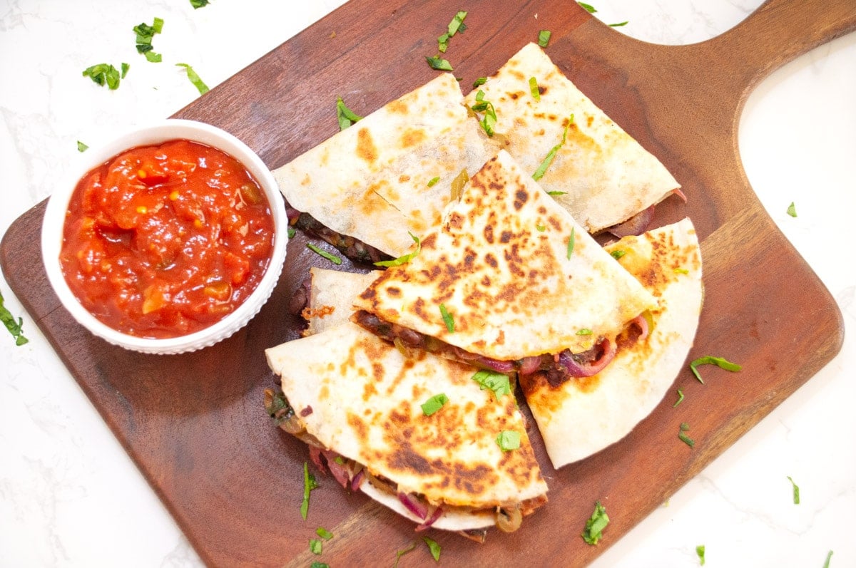 black bean spinach quesadilla on a wooden serving board