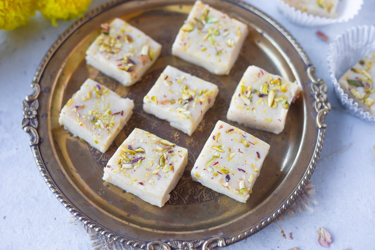 Kalakand garnished with pistachios in a plate. 