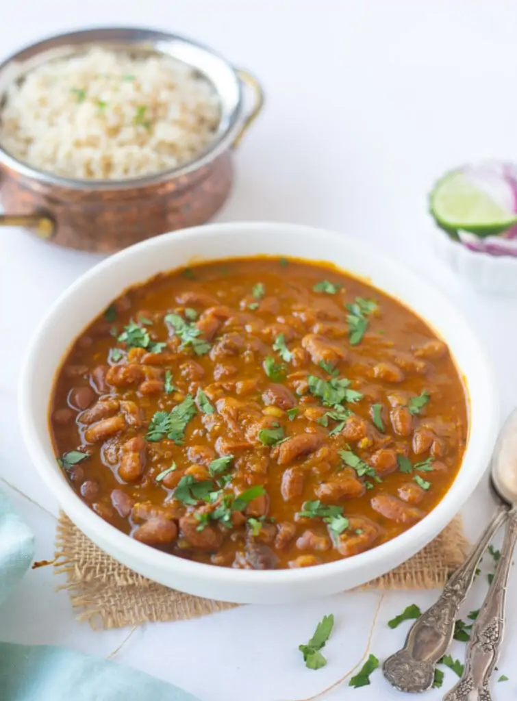 red kidney beans curry in a bowl garnished with cilantro leaves.