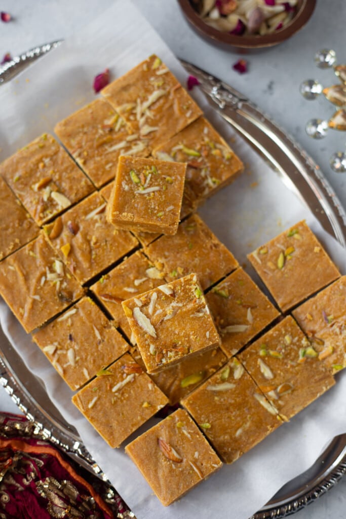 Pieces of Besan ki Burfi in a tray