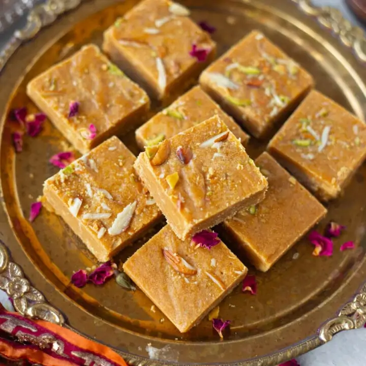 Besan Barfi (besan ki chakki) served in a bass pate garnished with nuts and rose petals