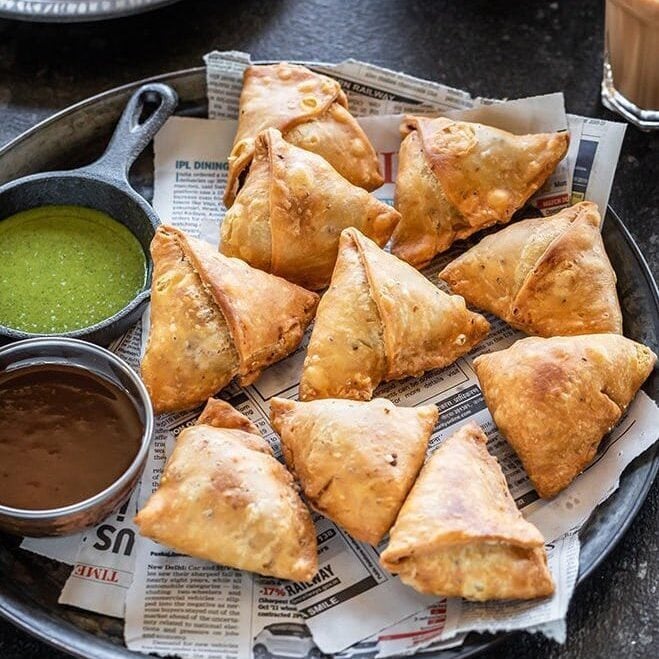 samosa on a plate with chutneys 