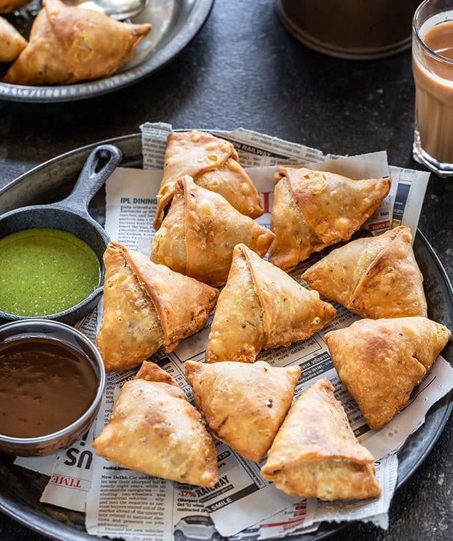 samosa on a plate with chutneys