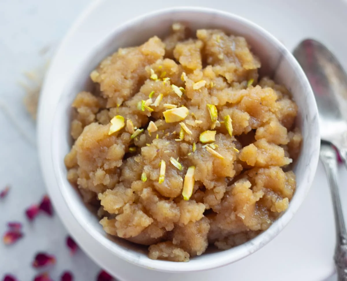 Aate ka halwa in a bowl topped with nuts