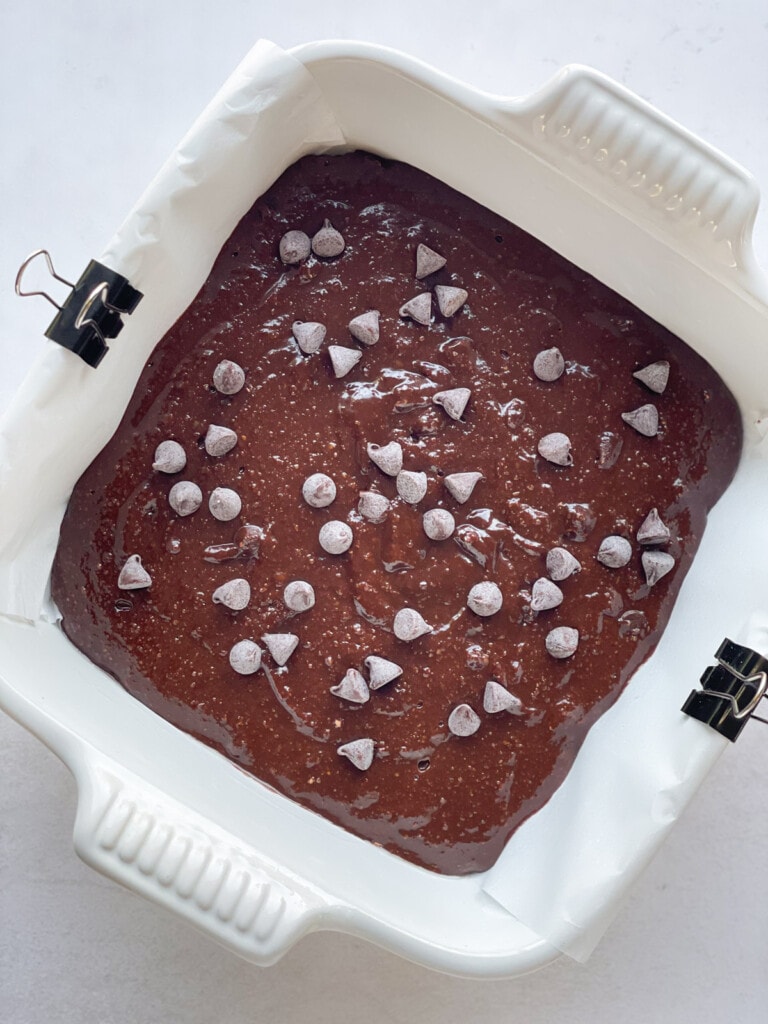 Batter for paleo brownies in a baking pan topped with chocolate chips