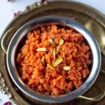 Carrot halwa in a bowl garnished with nuts