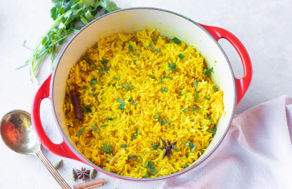 Perfectly cooked basmati turmeric yellow rice garnished with cilantro 
