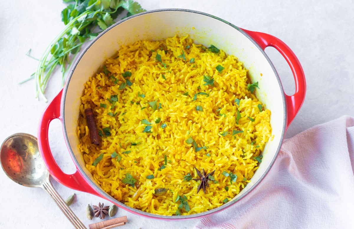 Perfectly cooked basmati turmeric yellow rice garnished with cilantro 