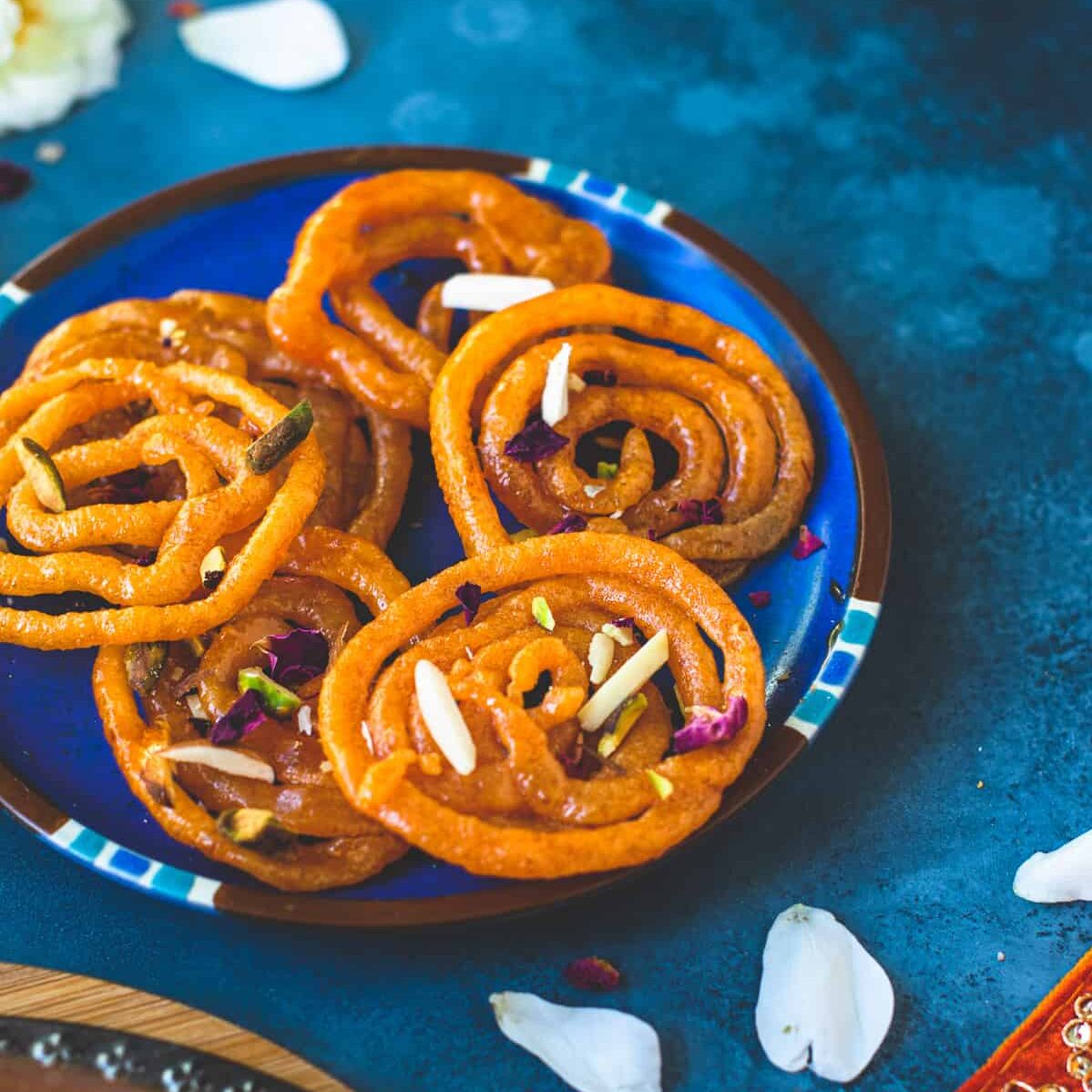 jalebi garnished with slivered nuts in a plate