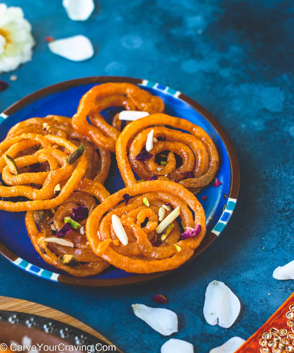 jalebi garnished with slivered nuts in a plate