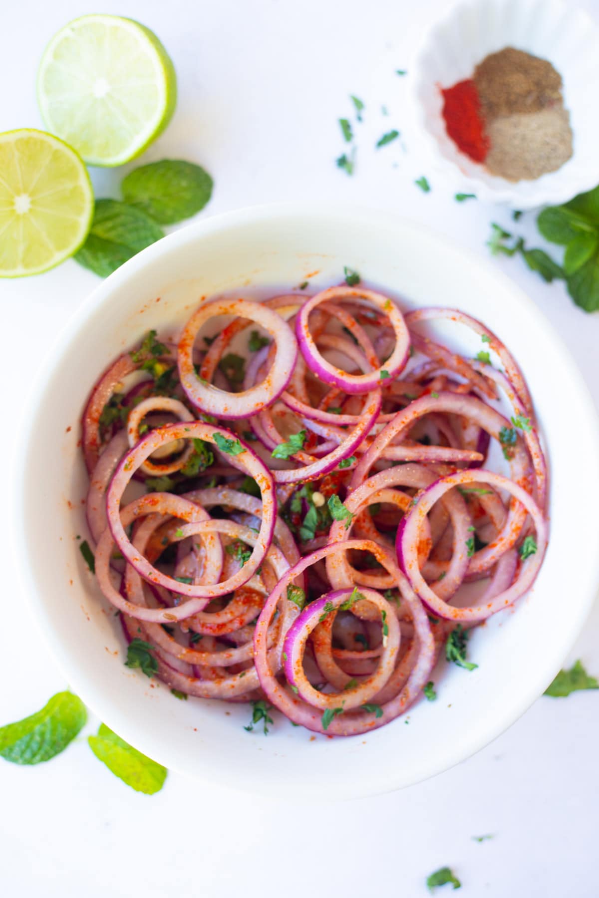 Laccha Pyaaz (indian onion salad) ina bowl garnished with cilantro  