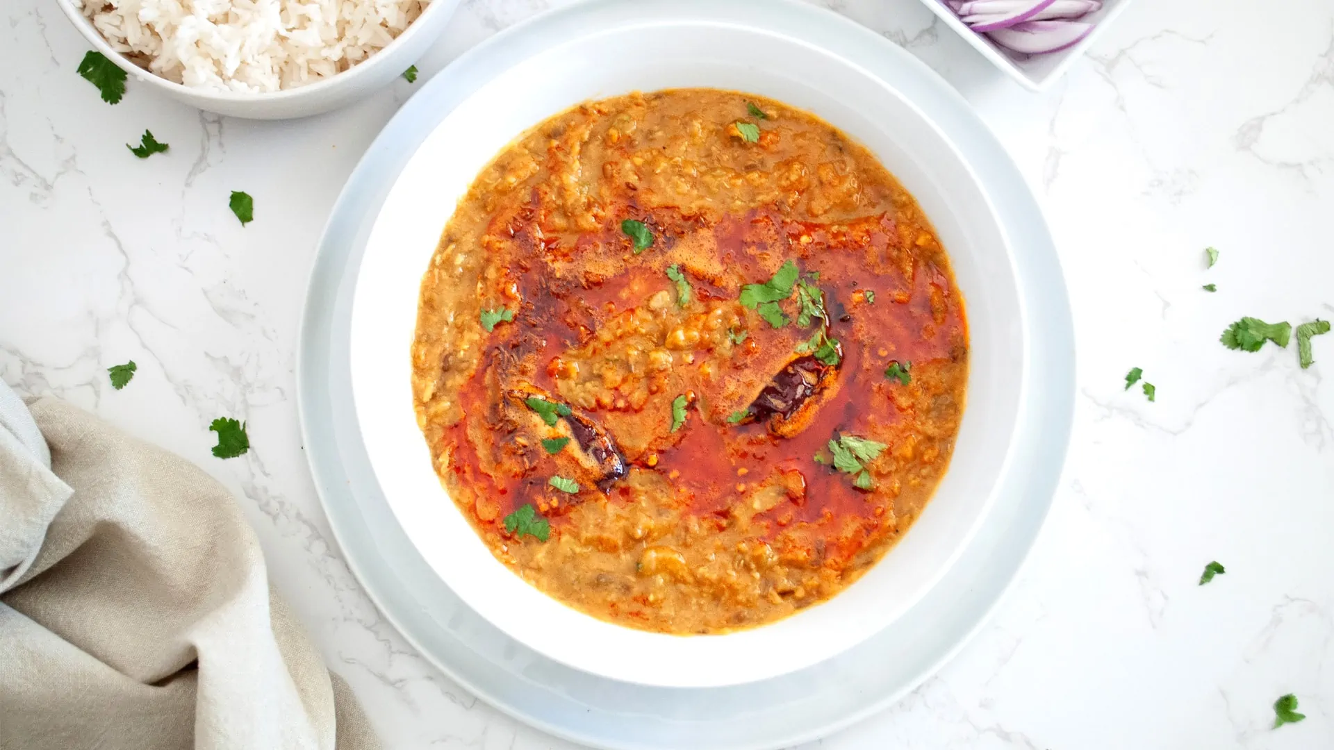 panchmel dal topped with tadka and cilantro leaves in a bowl 