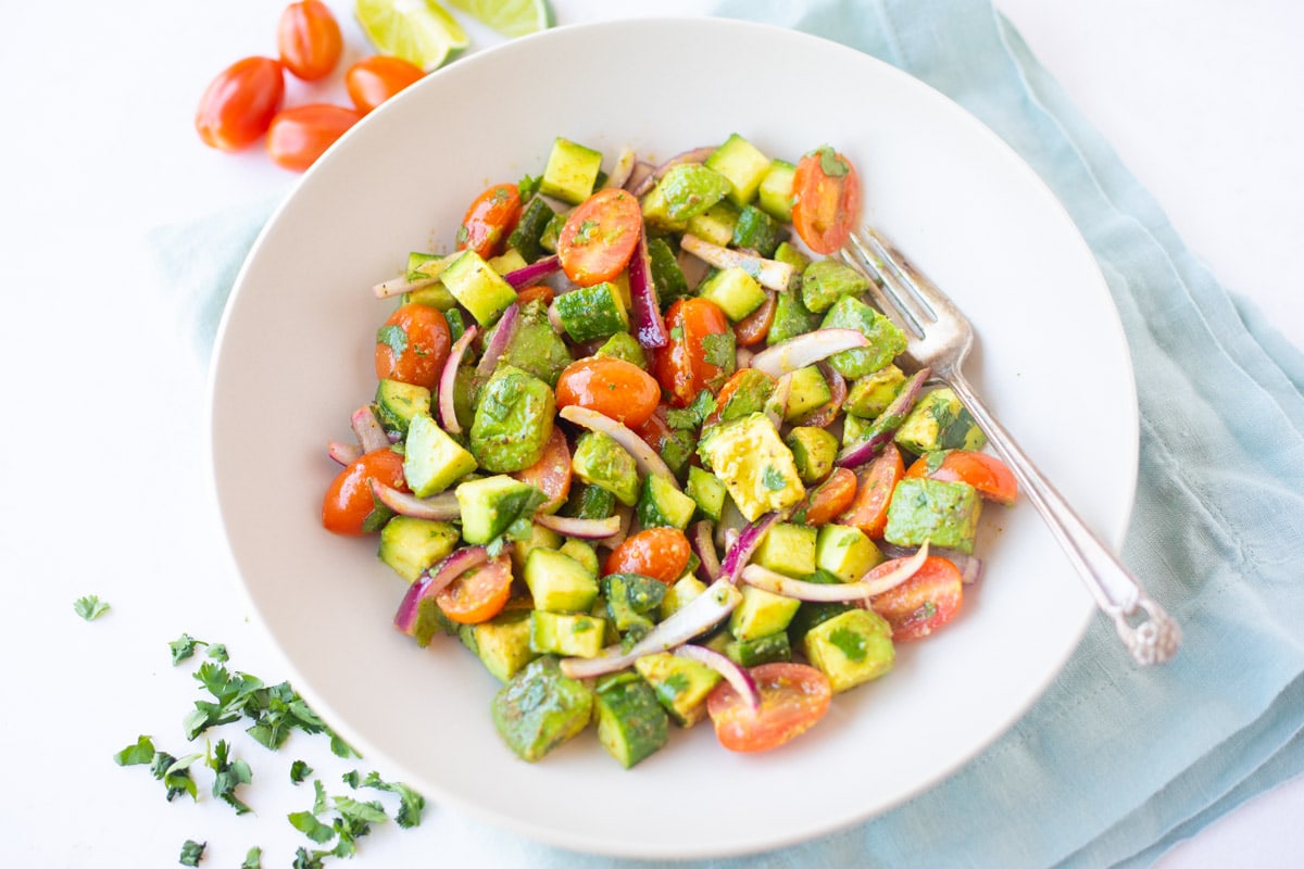 Refreshing Avocado cucumber tomato salad in a bowl 