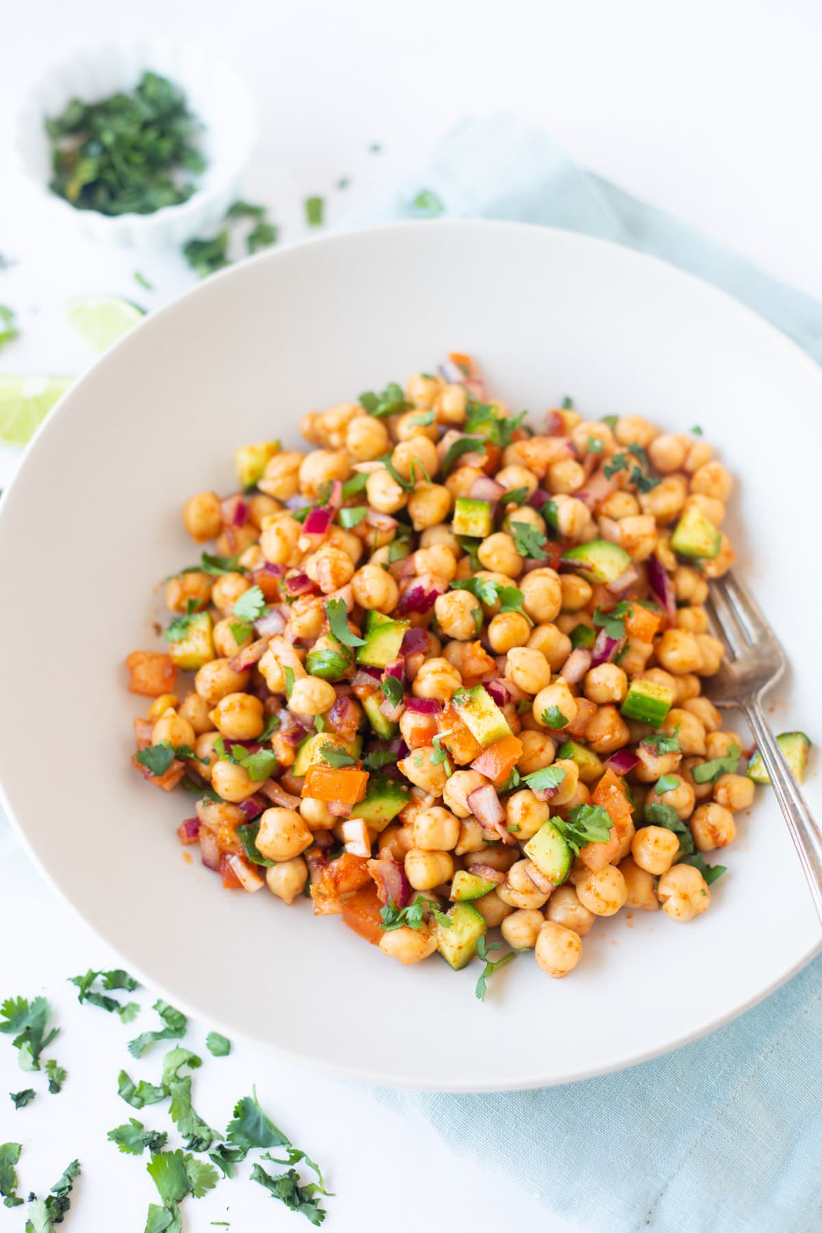 Easy garbanzo bean salad with veggies and spices in a white bowl