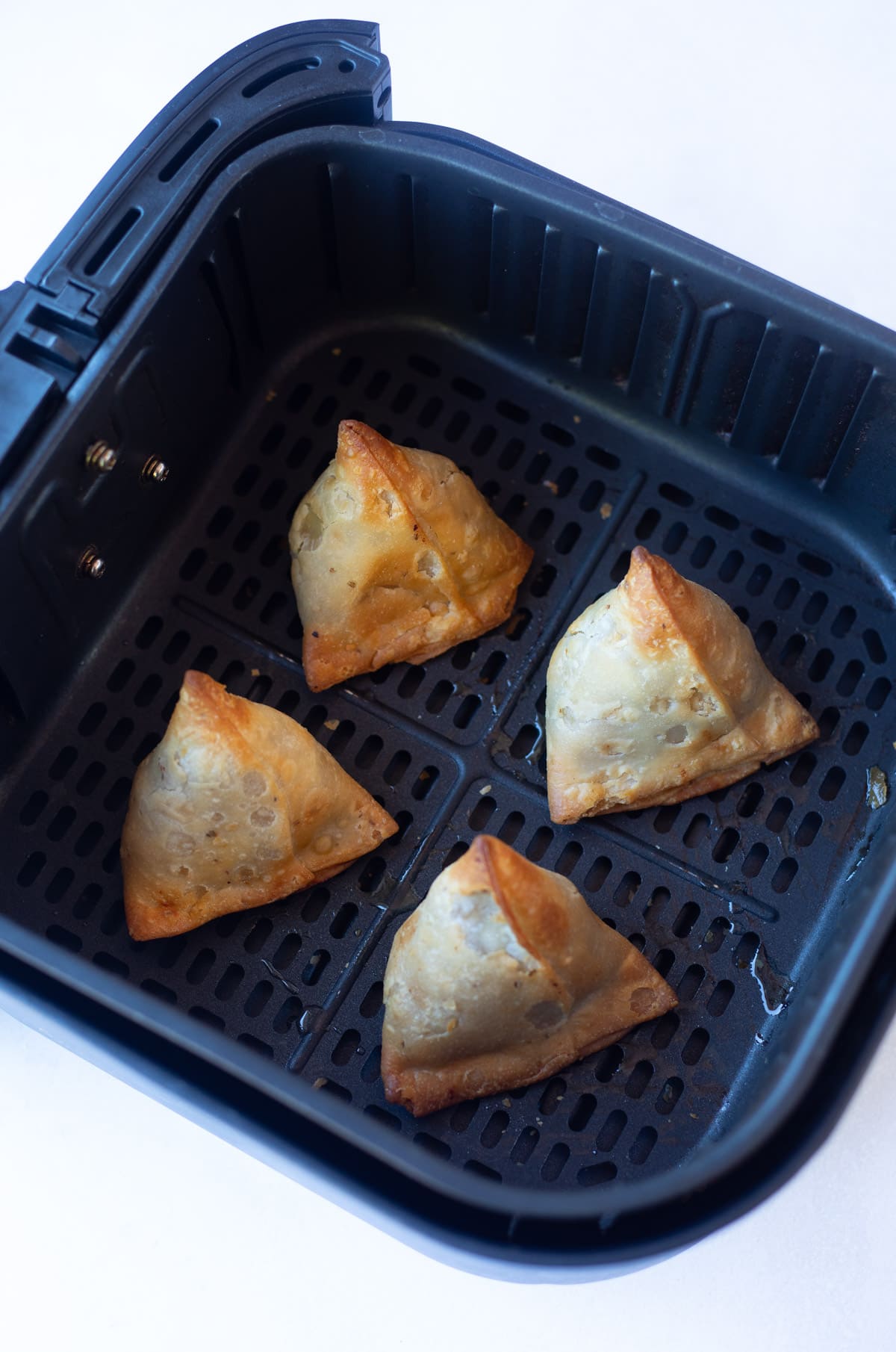 Air fried frozen samosa in the air fryer basket