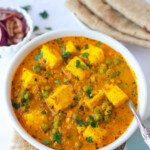 Matar Paneer served in a bowl with roti and onions on the side