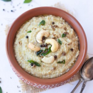 Millet pongal garnished with a tempering of cashews and curry leaves