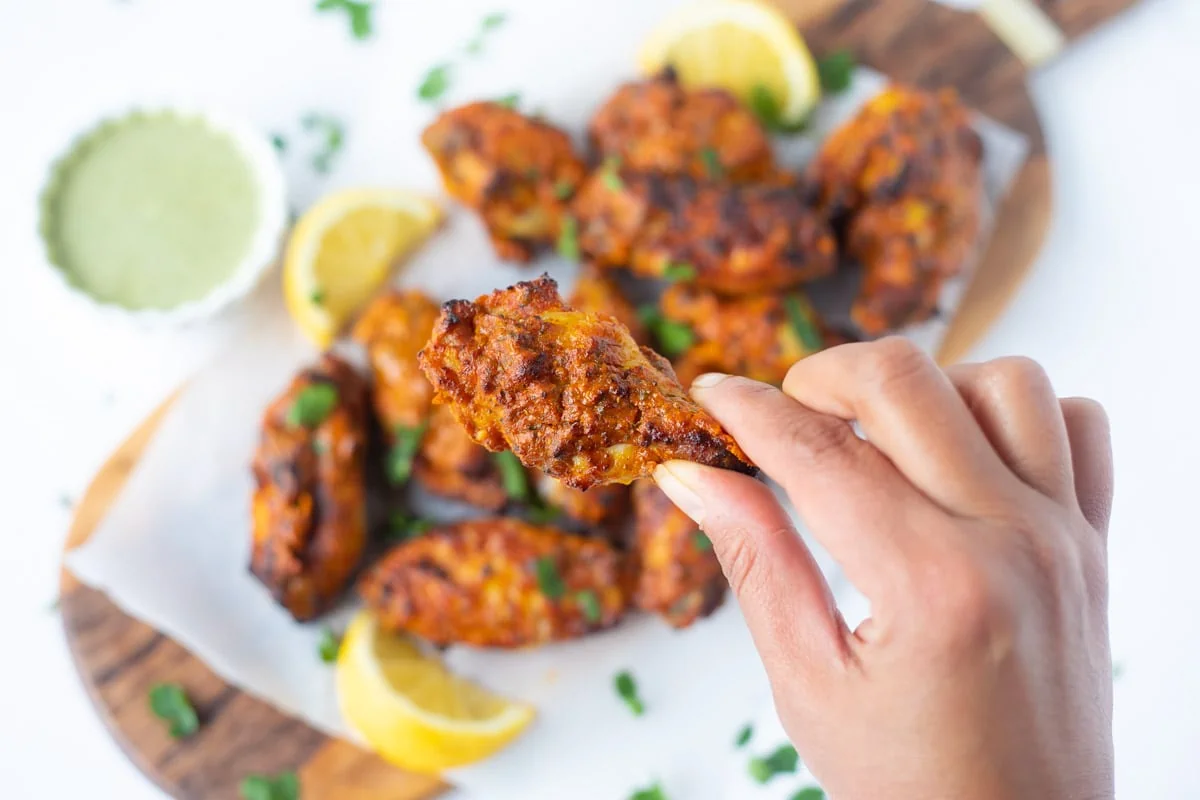 A tandoori chicken wing in hand