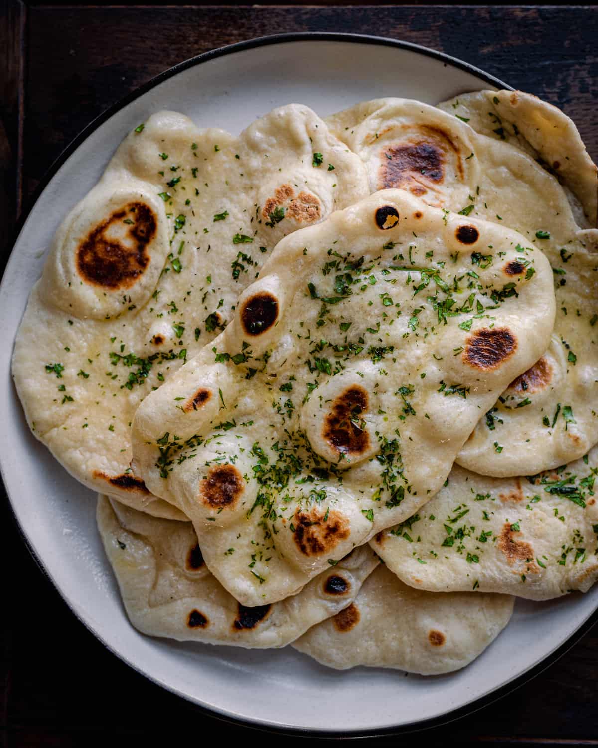 Naan bread in a plate garnished with cilantro 