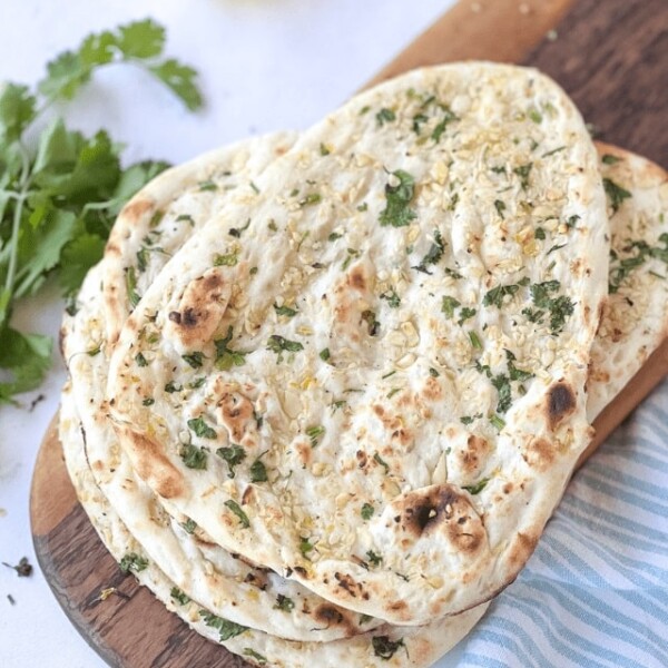 reheated naan in a platter with cilantro and butter on side