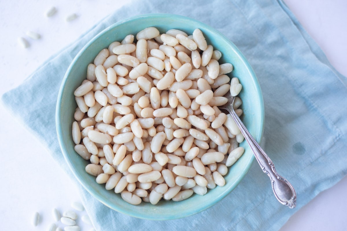 Instant pot cannellini beans in a bowl on a kitchen cloth