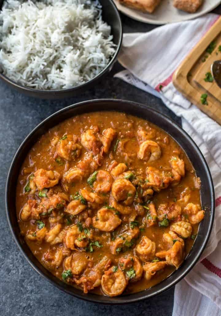 Prawns balchao in a serving bowl with rice on side