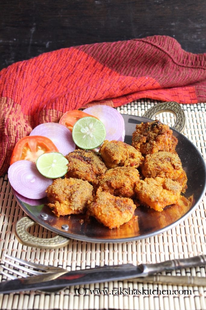 fried prawns with lime, tomato and onion on side in a pan