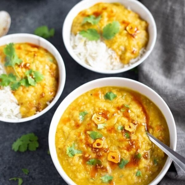 Red Lentils served in 3 bowls over rice and topped with cilantro