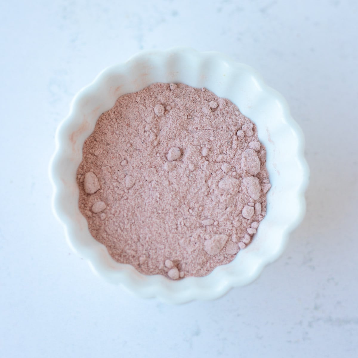 Black salt in a small white bowl.