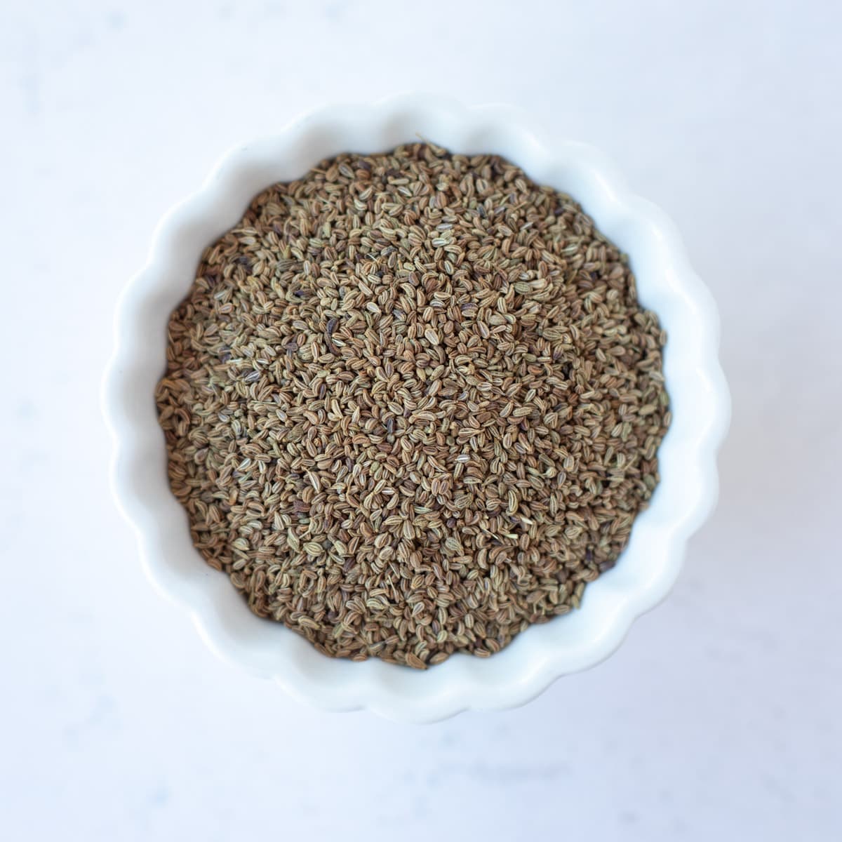 Carrom seeds in a small white bowl