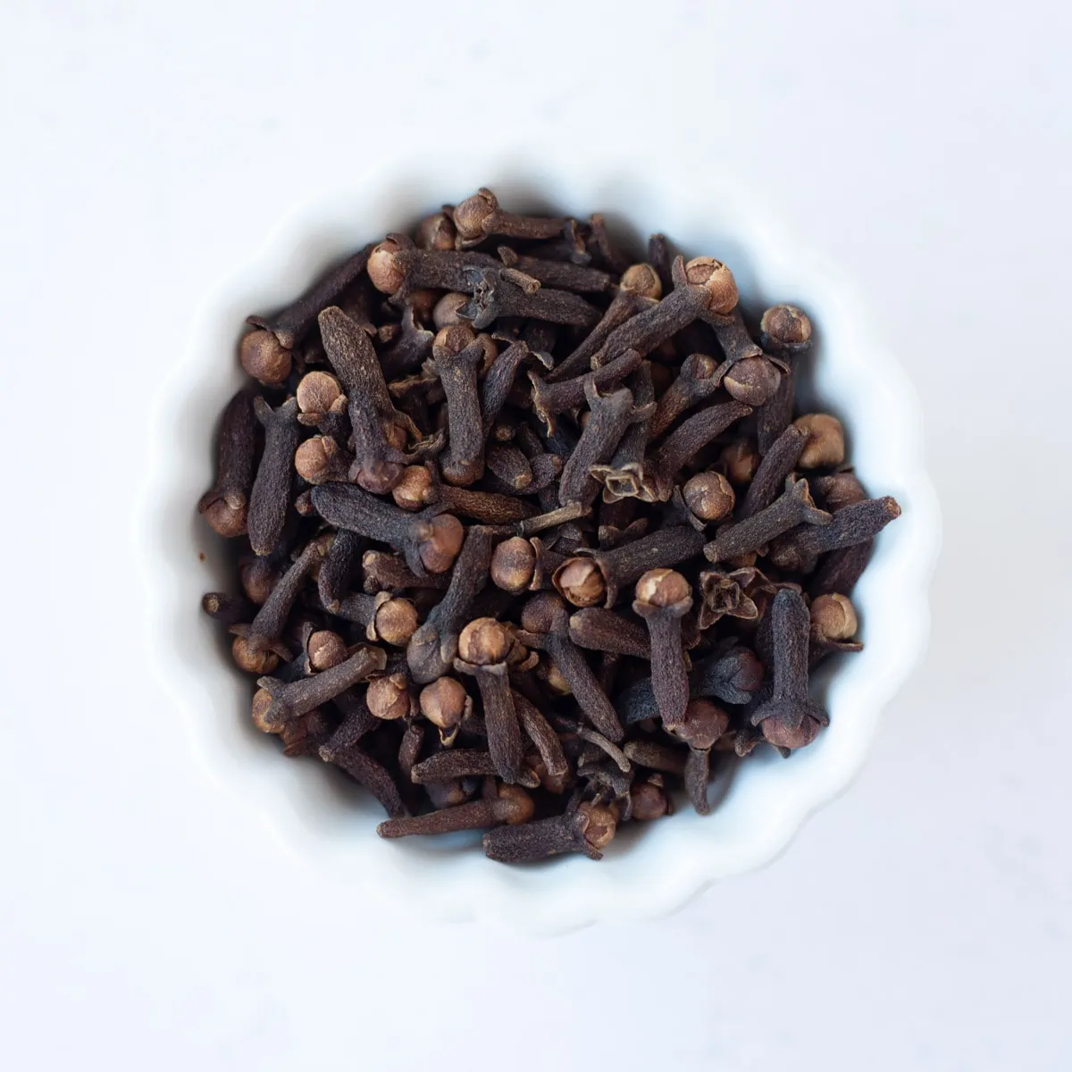 Cloves in a small white bowl.