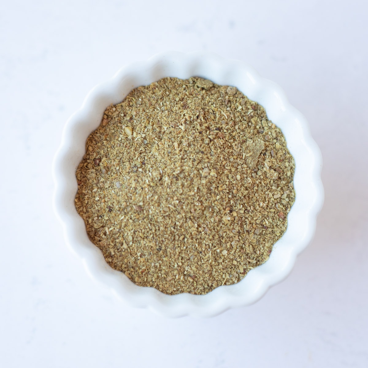 Corainder powder in a small white bowl.