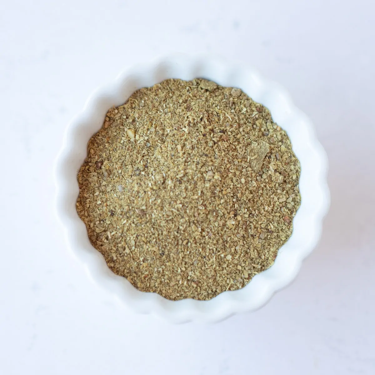 Corainder powder in a small white bowl.