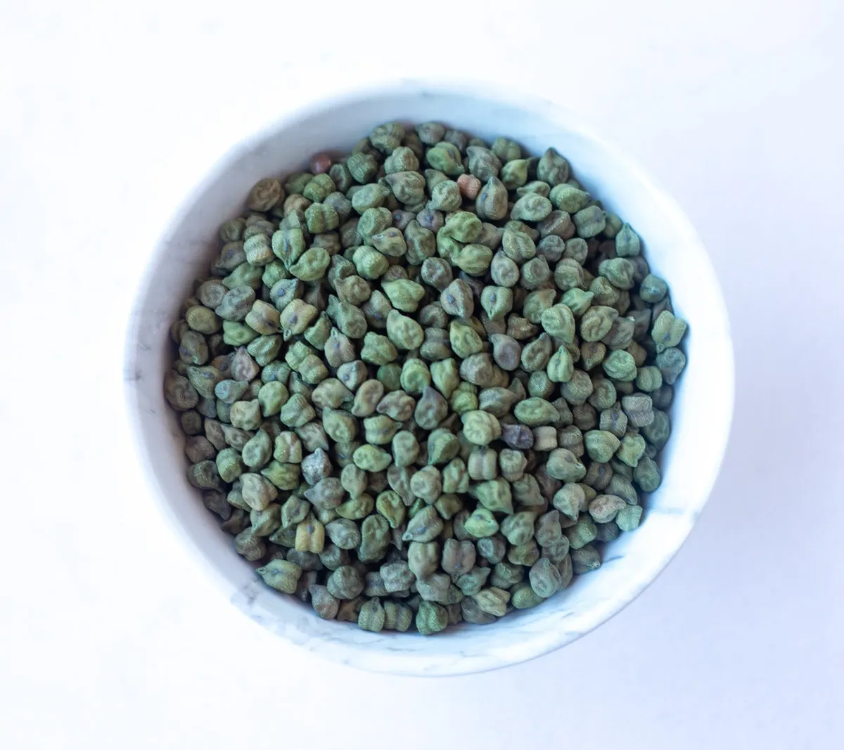 Dried Green Chickpeas, also called Hara Chana in a white bowl 