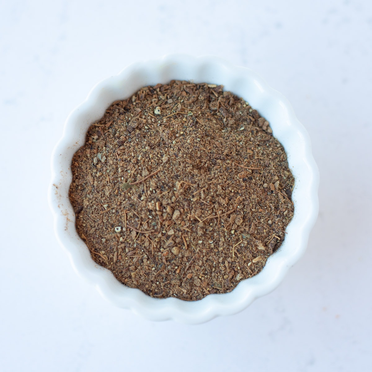 Garam masala in a small white bowl.