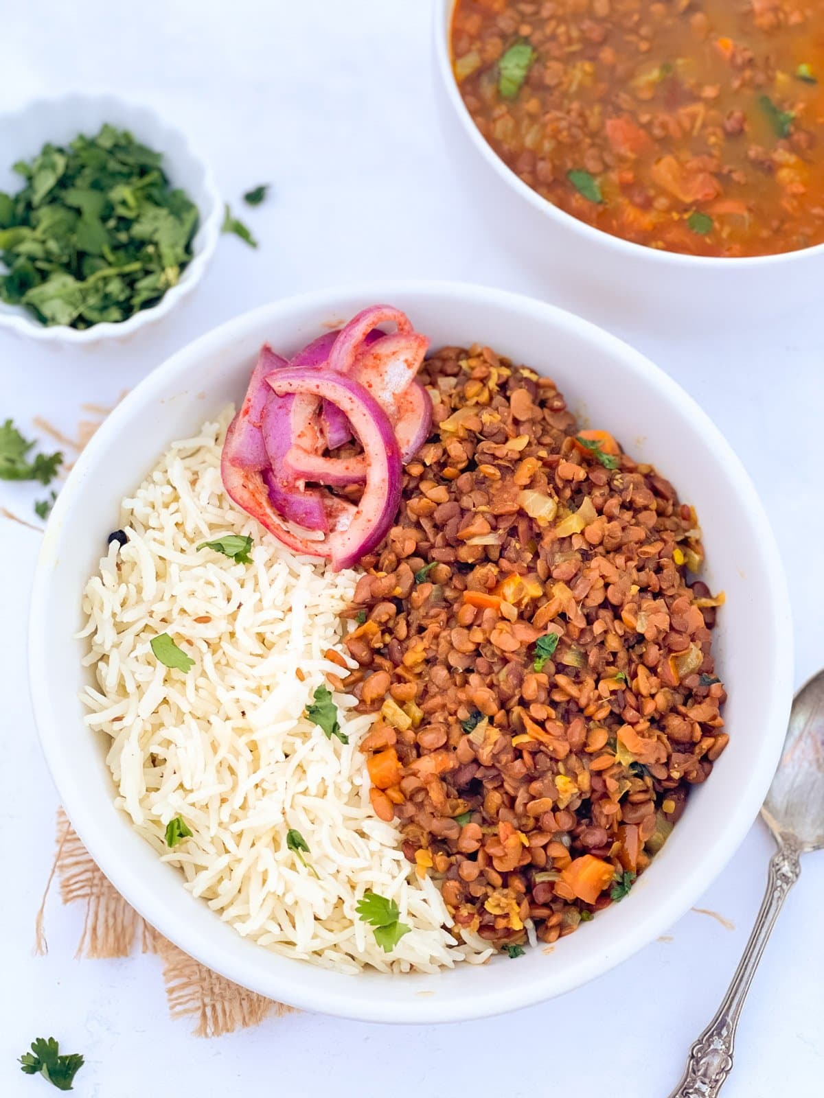 Horsegram dal served with rice in a bowl along with spiced onions 