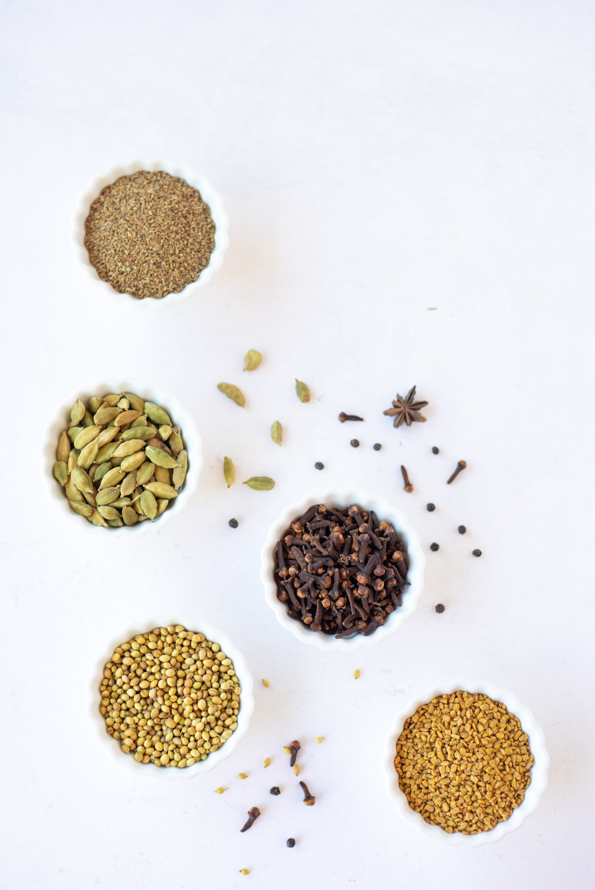 Indian spices in small white bowls 