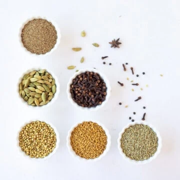 Indian spices and herbs in white bowls