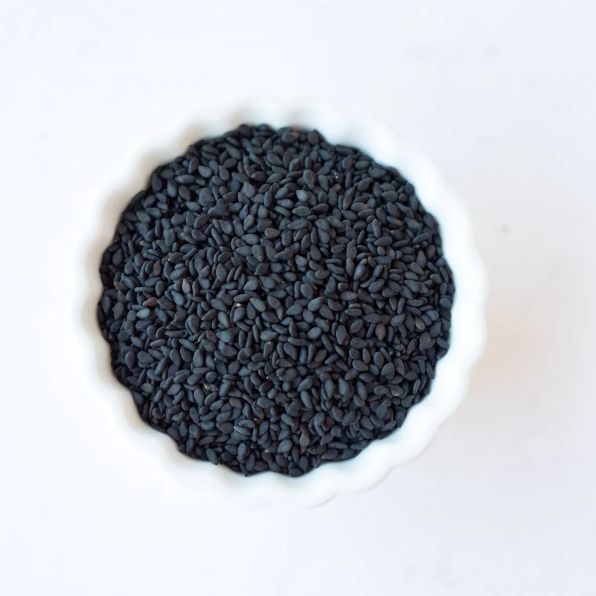 Nigella seeds in a small white bowl.