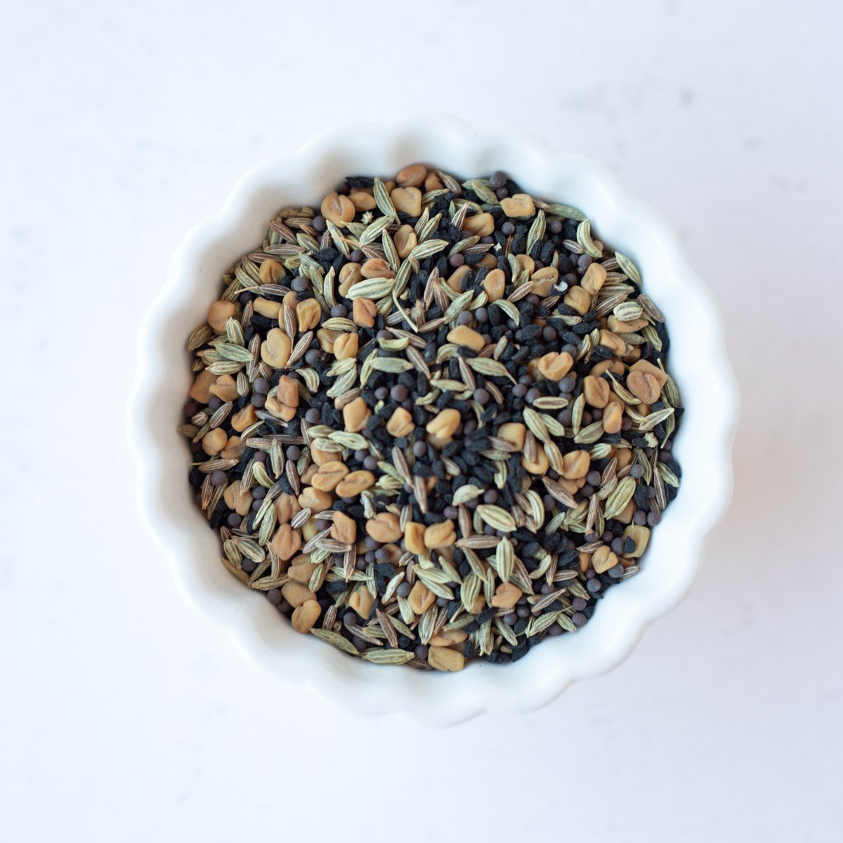 panch phoran spice mix in a white bowl
