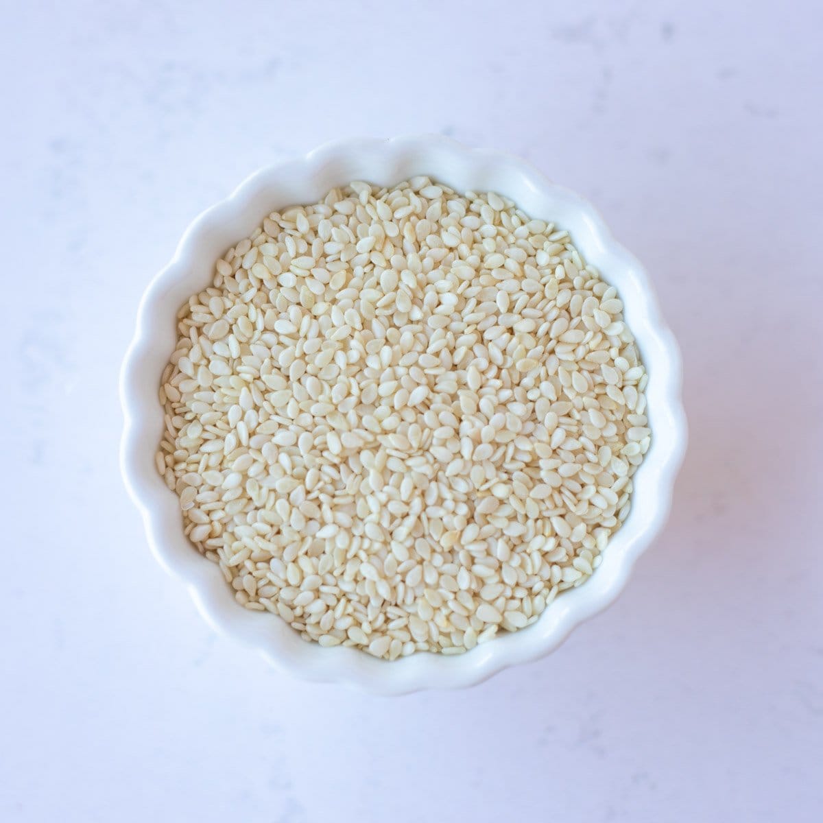 Sesame seeds in a small white bowl.