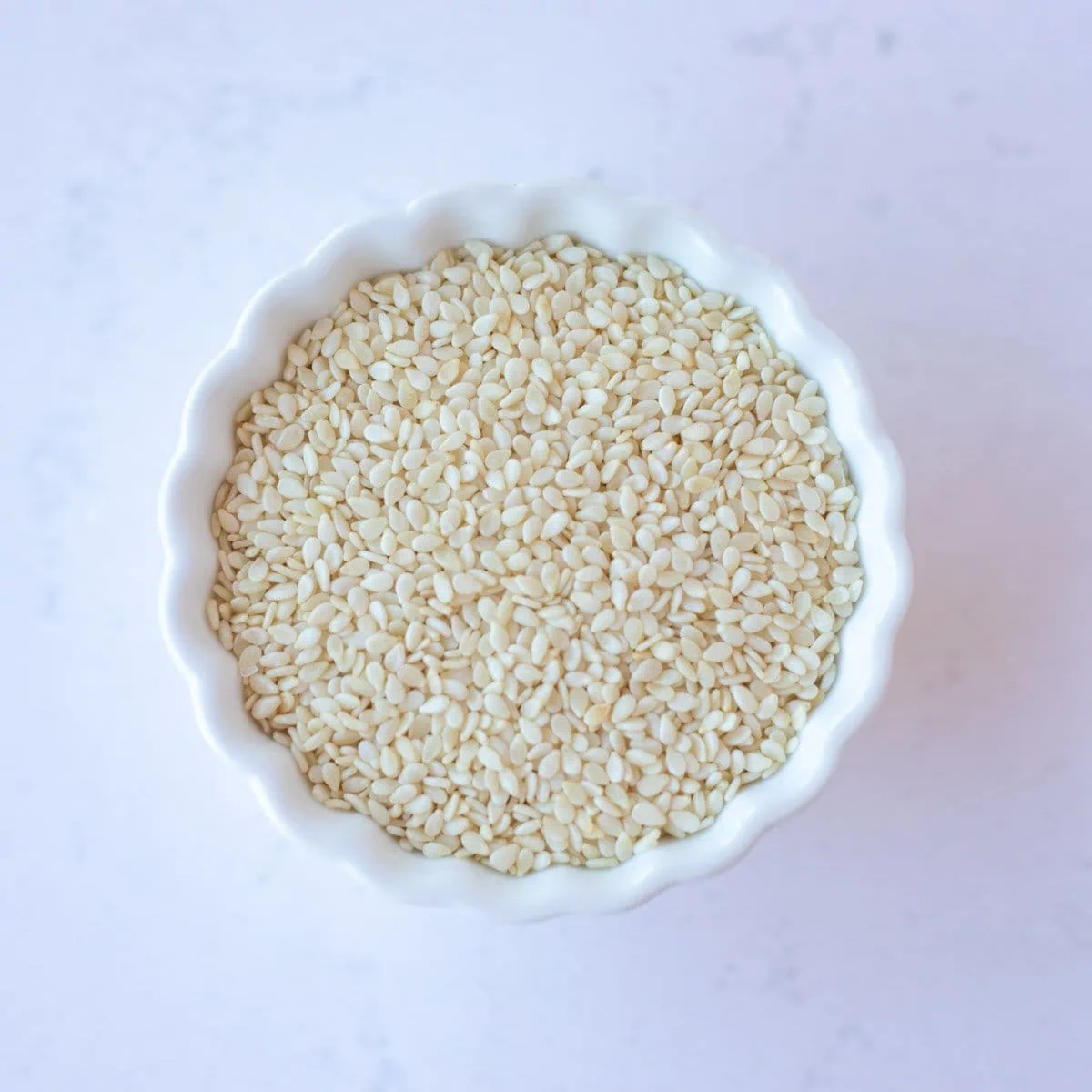 Sesame seeds in a small white bowl.