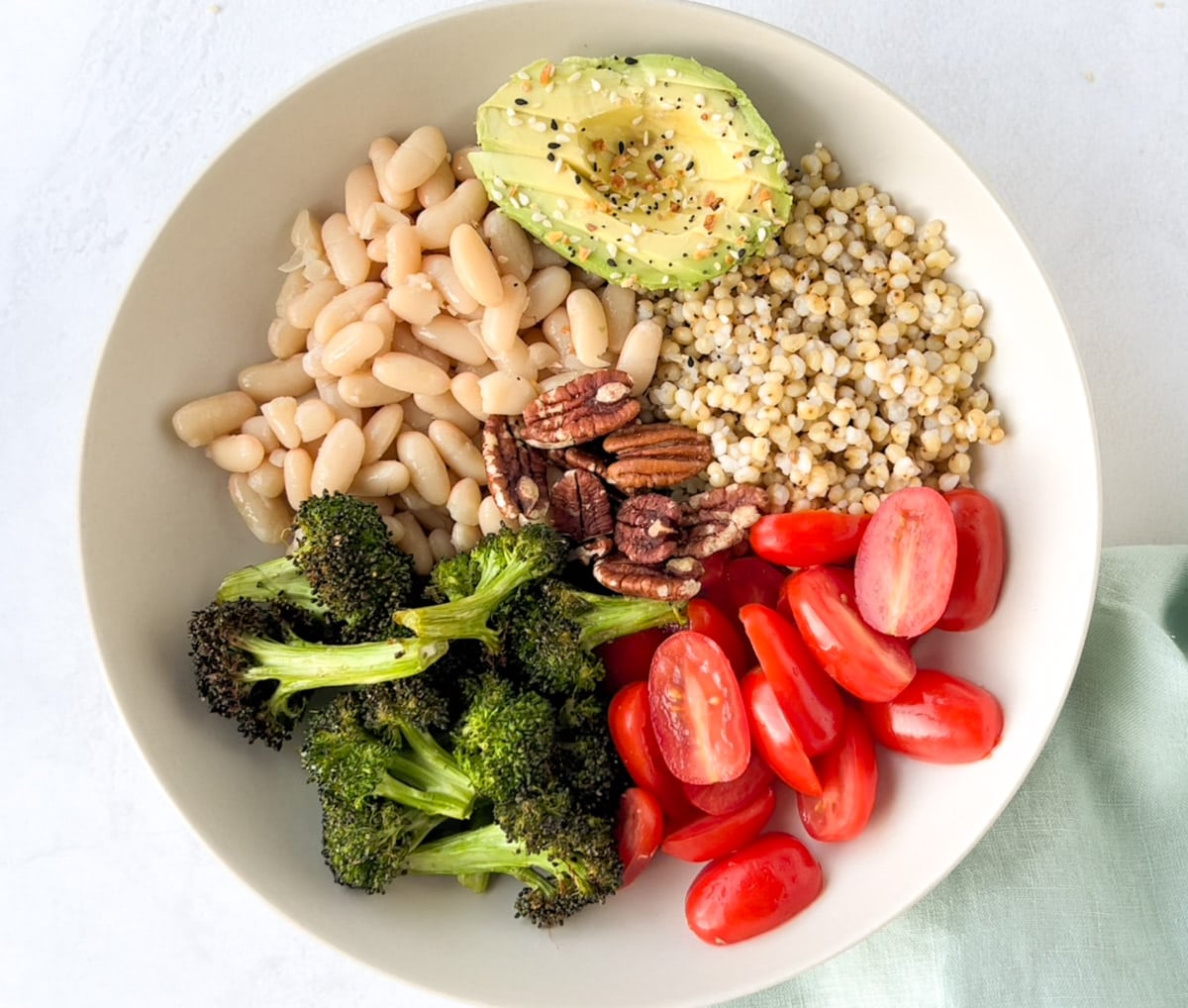 A grain bowl with sorghum, beans, veggies and avocado