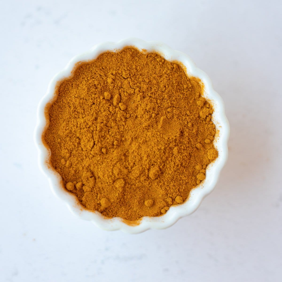 Turmeric powder in a small white bowl.