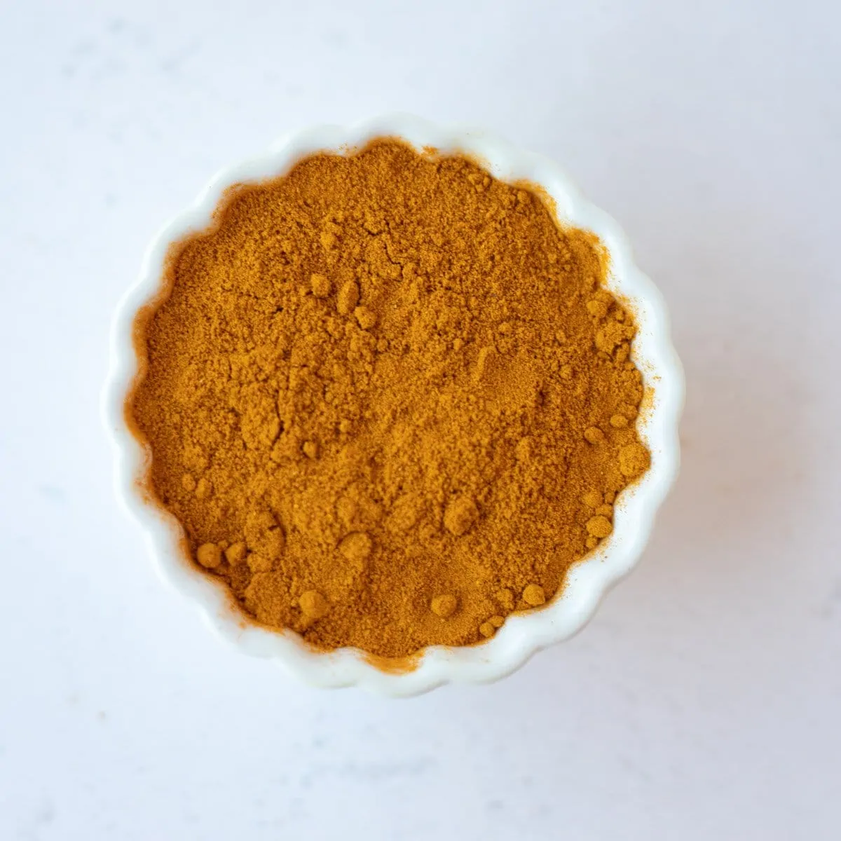 Turmeric powder in a small white bowl.