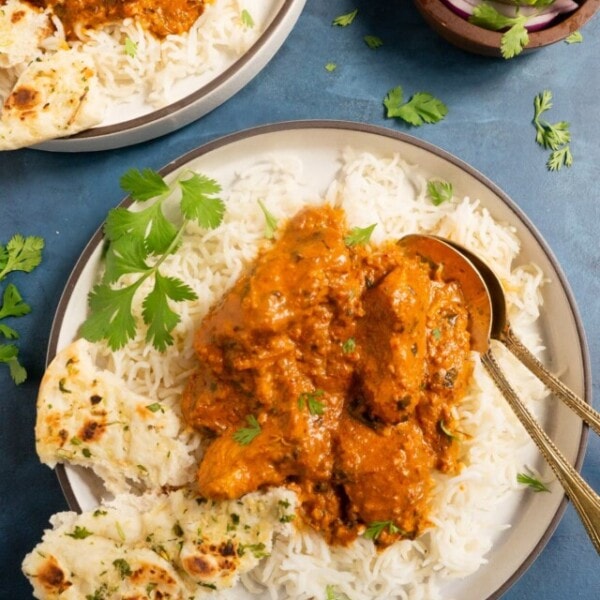 Chicken tikka masala served over rice along with pieces of garlic naan