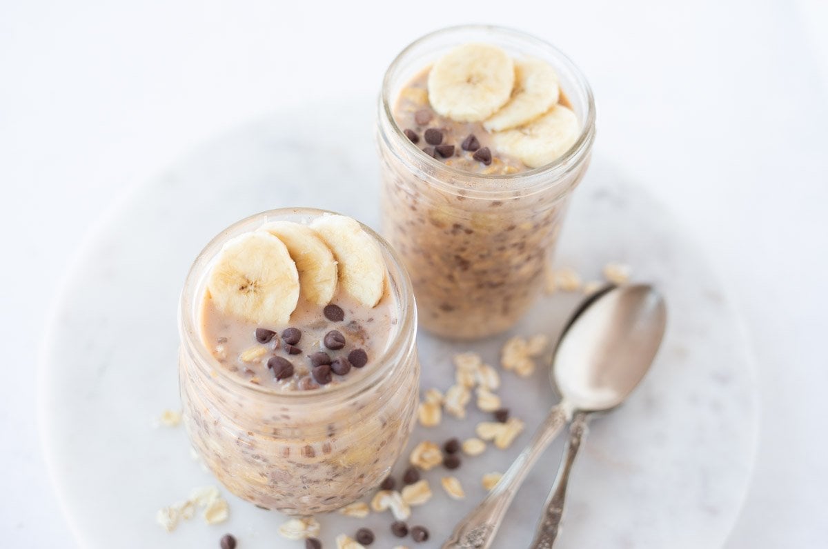 2 glass jar with Chocolate Chip Banana Overnight Oats topped with banana and chocolate chips