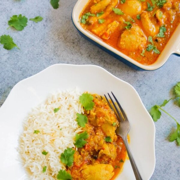 Chicken curry with rice in a plate, and chicken curry in a square bowl