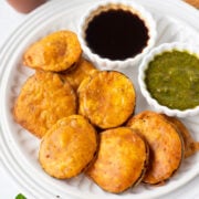 Brinjal Pakoda garnished with mint and cilantro in a plate