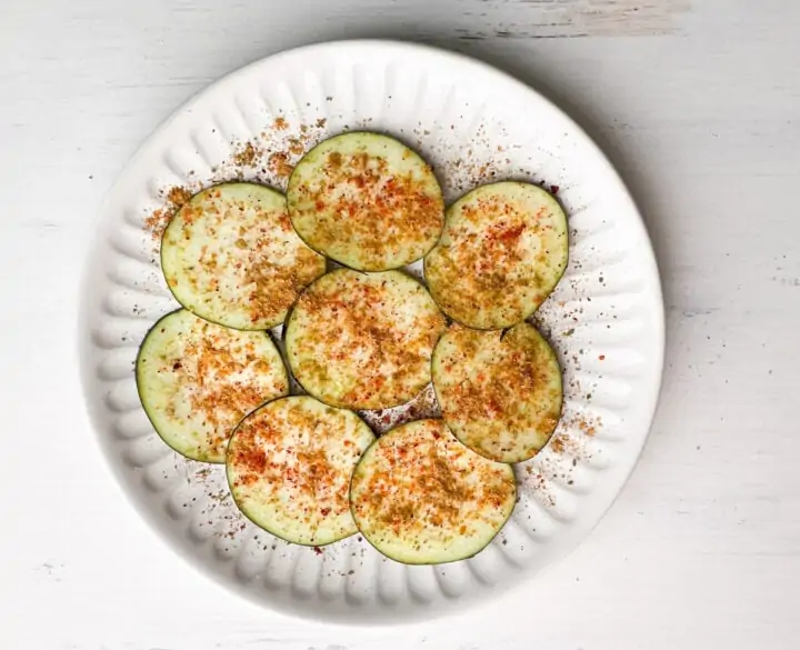 sliced baingan topped with spices in a plate